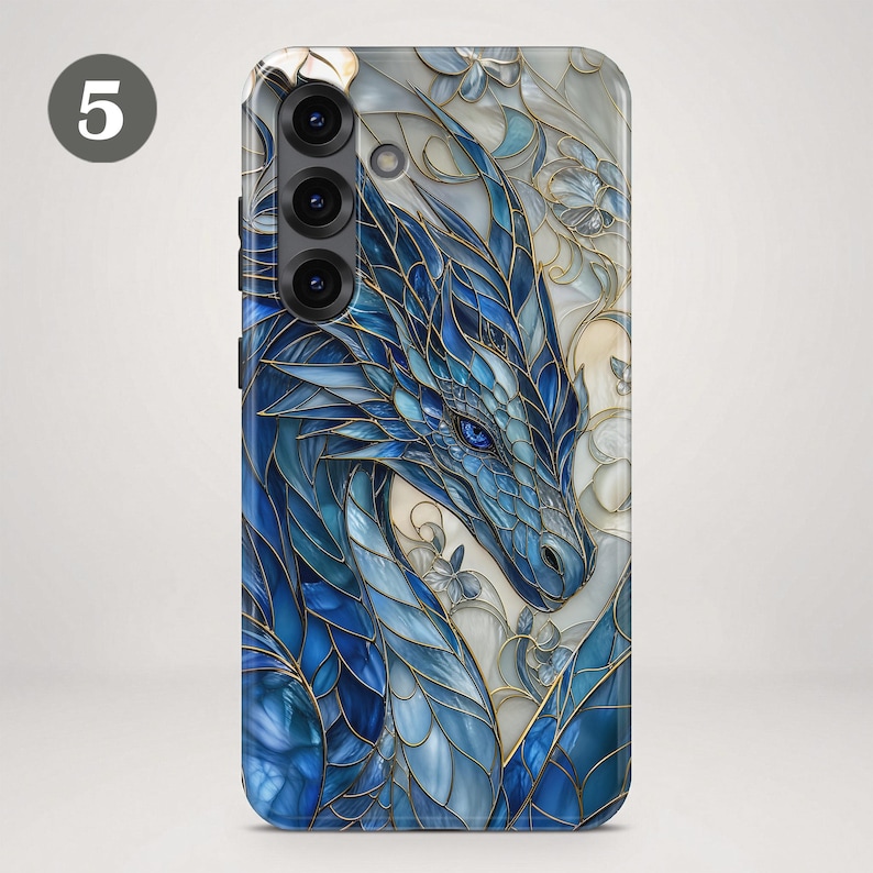 May include: A smartphone case featuring a stained glass design of a blue dragon with intricate gold outlines. The dragon is set against a background of white and cream floral patterns, with a prominent number 5 in the upper left corner.