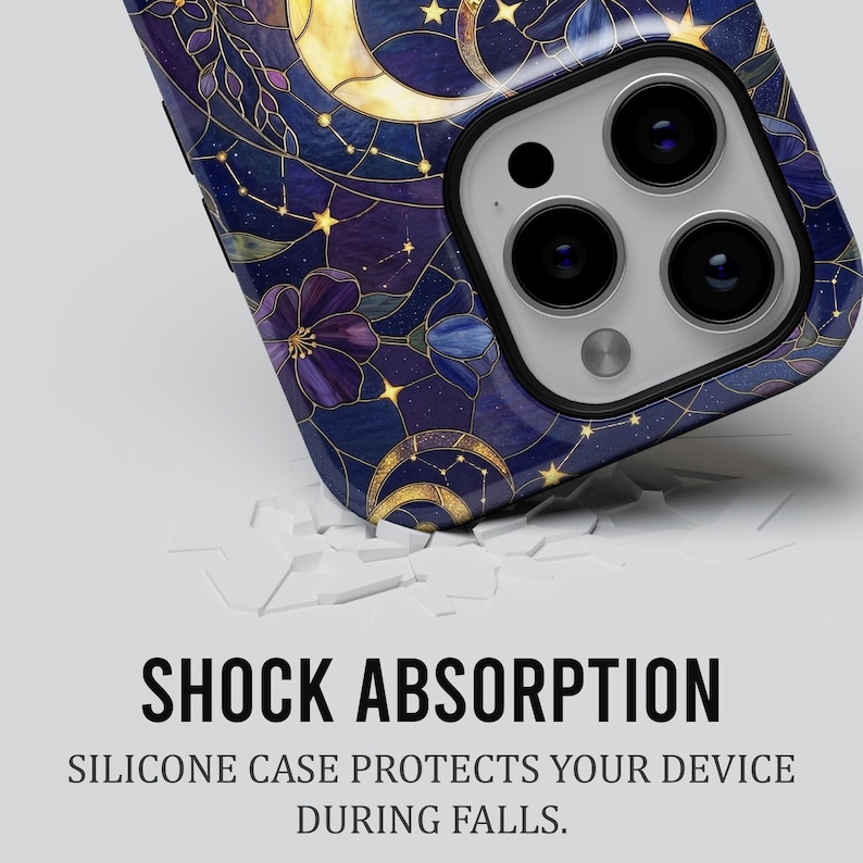 May include: A phone case with a celestial design is shown. The case has a dark blue background with gold crescent moons, stars, and purple floral accents. The text "SHOCK ABSORPTION" is displayed in bold black letters.