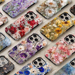 May include: A collection of floral-patterned phone cases. The cases feature various flower designs in shades of red, pink, yellow, purple, and white. The cases are arranged on a light-colored surface, showcasing the intricate floral patterns.
