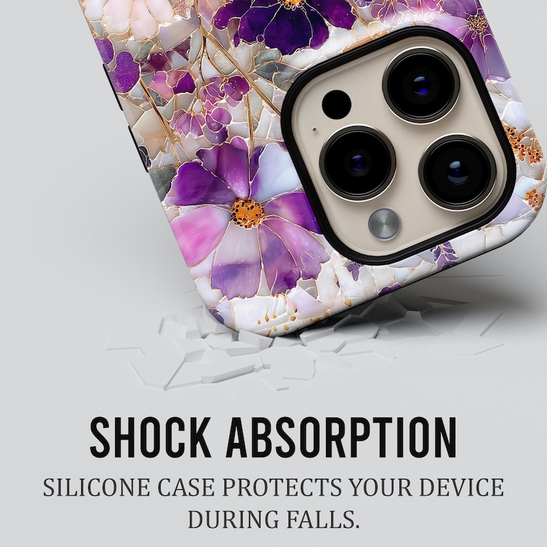 May include: A close-up of a phone case with a floral design in shades of purple, pink, and white. The case has a glossy finish and a black camera module. The text "SHOCK ABSORPTION" and "SILICONE CASE PROTECTS YOUR DEVICE DURING FALLS" are visible.