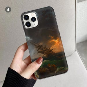 Peut inclure: Une coque de t&eacute;l&eacute;phone transparente avec une image de paysage marin sombre et orageux. L'image repr&eacute;sente un navire dans une mer orageuse avec un &eacute;clair au loin. La coque a une d&eacute;coupe d'appareil photo noire avec trois objectifs.