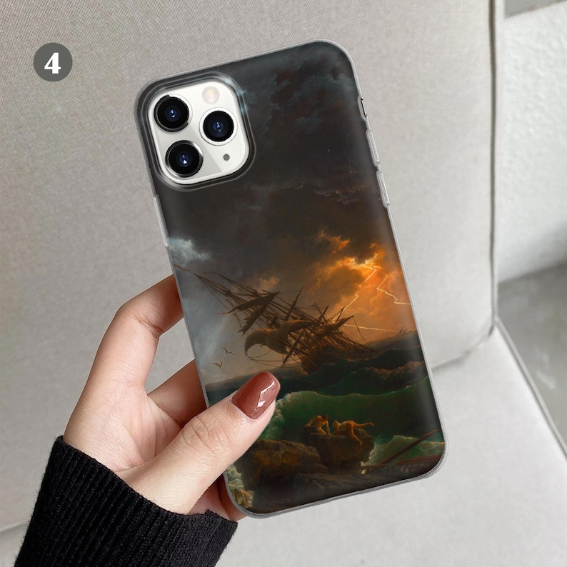 Peut inclure: Une coque de t&eacute;l&eacute;phone transparente avec une image de paysage marin sombre et orageux. L'image repr&eacute;sente un navire dans une mer orageuse avec un &eacute;clair au loin. La coque a une d&eacute;coupe d'appareil photo noire avec trois objectifs.
