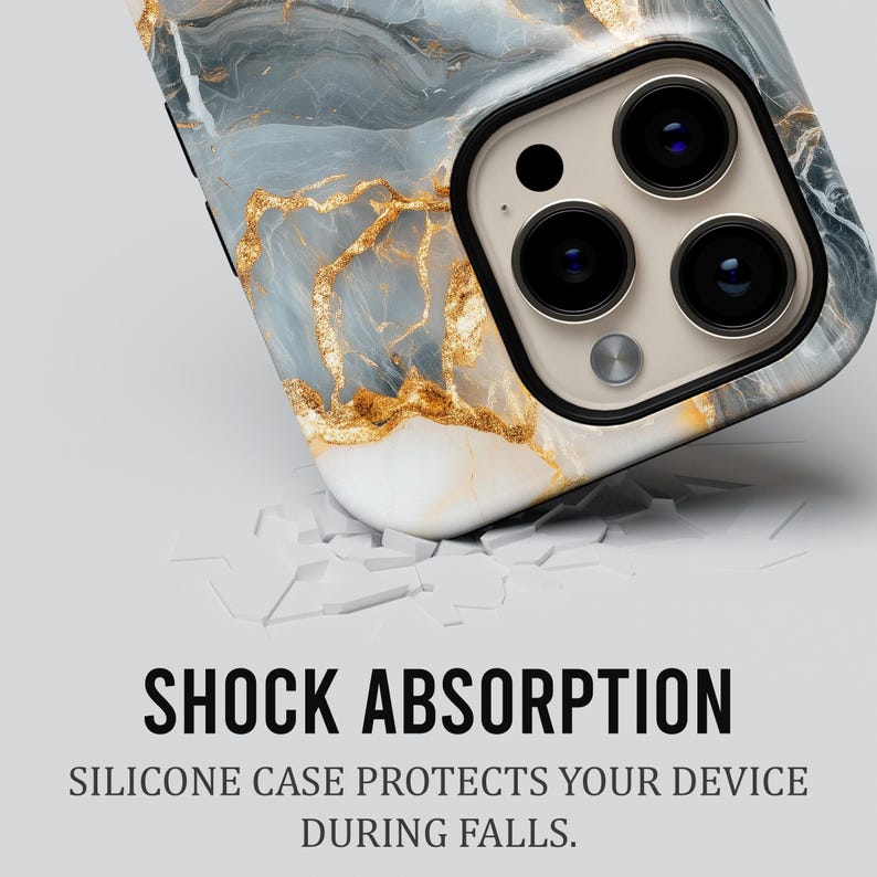 May include: A white phone case with a blue and gold marble design. The case is cracked, suggesting it has been dropped. The text "SHOCK ABSORPTION" and "SILICONE CASE PROTECTS YOUR DEVICE DURING FALLS." is displayed below the case.