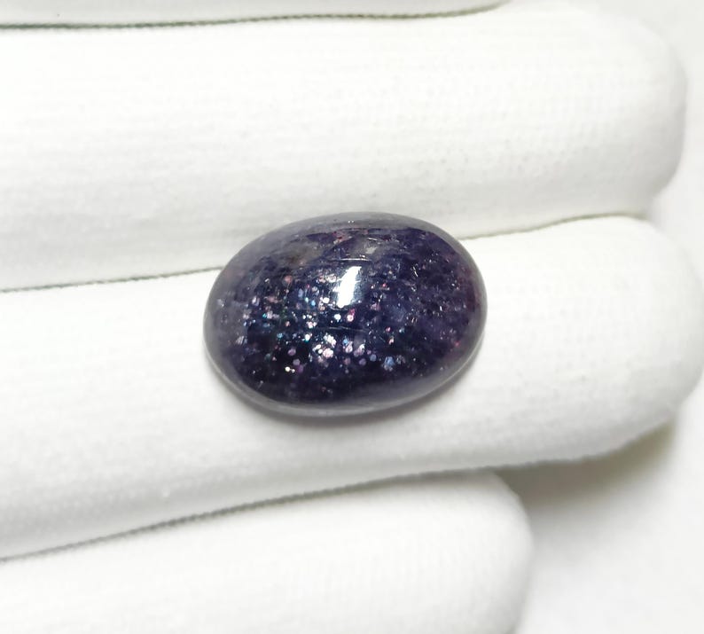 May include: A dark purple oval-shaped gemstone with a sparkly, iridescent finish.