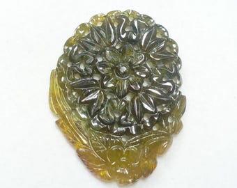May include: A carved green and yellow gemstone pendant in the shape of a flower with intricate details.
