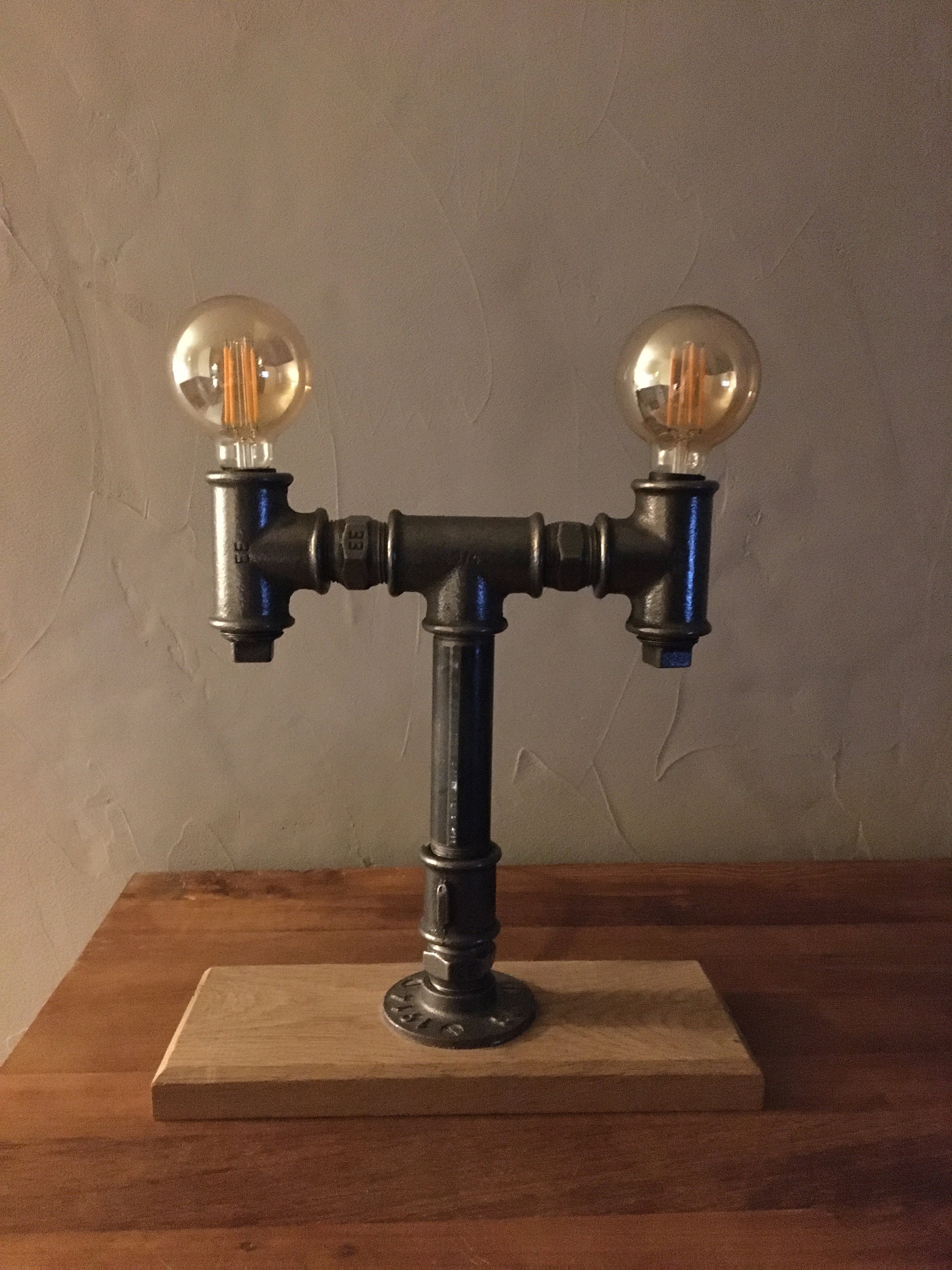 Lampe à Poser Réalisé A Partir de Coudes Plomberie en Fonte Le Tout Monté sur Un Socle Chêne Massif.