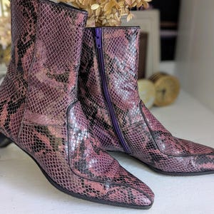 Peut inclure: Une paire de bottes en cuir de serpent violet à bout pointu et fermeture éclair dans le dos.