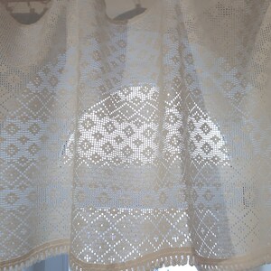 May include: White crocheted valance with a diamond pattern. The valance has a fringe trim.