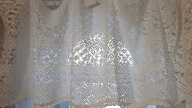 May include: White crocheted valance with a diamond pattern. The valance has a fringe trim.