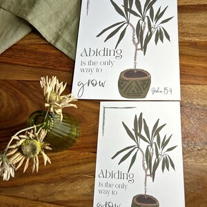May include: A white printable card with a green plant in a brown pot. The text on the card reads "Abiding is the only way to grow John 15:4".