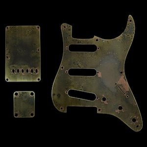 Könnte beinhalten: Ein Satz von drei Gitarren-Pickguards in einem abgenutzten, gealterten Kupferfinish. Die Pickguards sind aus Metall und haben eine strukturierte Oberfläche. Die Pickguards sind für eine E-Gitarre.