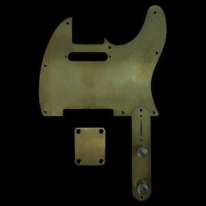 May include: A set of brass guitar parts, including a pickguard, control plate, and neck plate, against a black background. The pickguard has a rectangular cutout and screw holes. The control plate has two knobs. The neck plate is square with four holes.