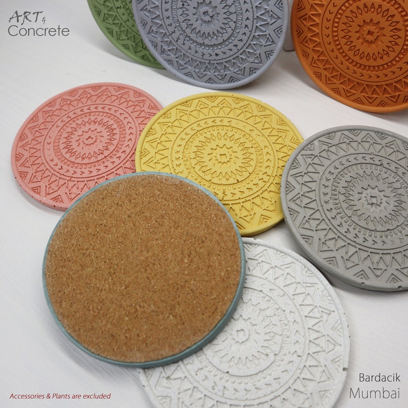Puede incluir: Conjunto de seis posavasos redondos de hormig&oacute;n con dise&ntilde;os geom&eacute;tricos en varios colores, incluyendo gris, amarillo, naranja, rosa, blanco y marr&oacute;n. Los posavasos tienen un dise&ntilde;o en relieve y est&aacute;n hechos de hormig&oacute;n. El texto "ART Concrete" y "Bardacik Mumbai" es visible en la imagen.