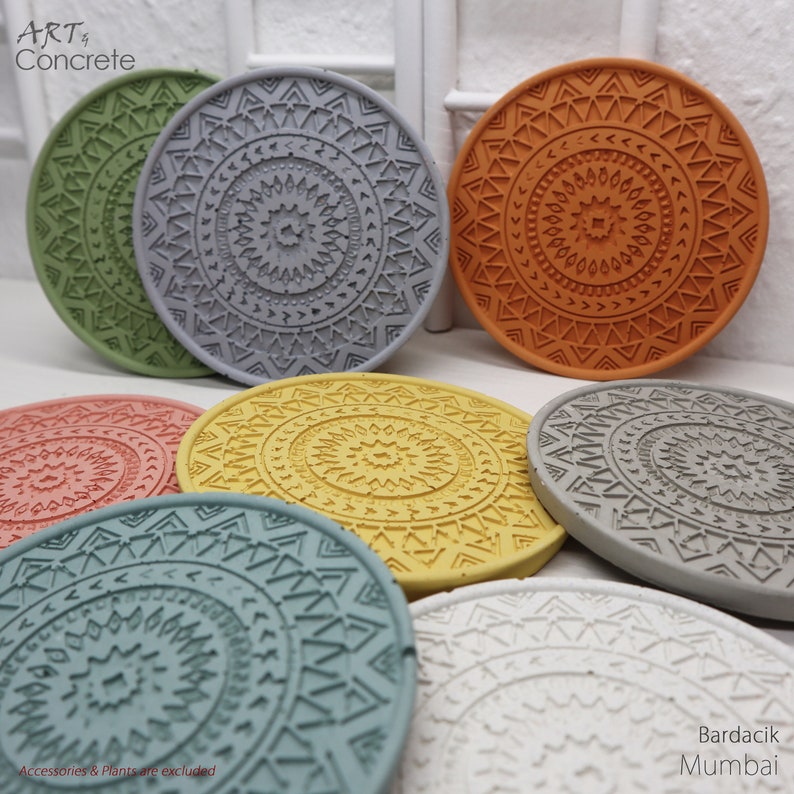 Puede incluir: Conjunto de seis posavasos redondos de hormig&oacute;n con dise&ntilde;os geom&eacute;tricos en varios colores, incluyendo gris, verde, amarillo, naranja, rosa y blanco. Los posavasos presentan un patr&oacute;n tipo mandala con un c&iacute;rculo central y anillos conc&eacute;ntricos de tri&aacute;ngulos y otras formas. El texto "Bardacik Mumbai" es visible en la esquina inferior derecha de la imagen.
