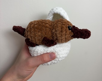 Peluche de ornitorrinco tejido a crochet en un huevo