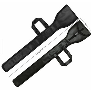 Könnte beinhalten: Schwarze Gitarrentasche mit einer Länge von 92 cm und einer Breite von 18 cm. Die Tasche hat einen Griff und einen Gurt.
