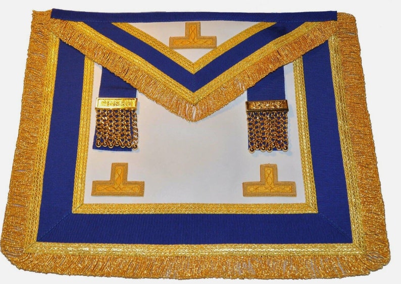 K&ouml;nnte beinhalten: Wei&szlig;er Freimaurer-Schurz mit goldenen Verzierungen und blauem Band. Der Schurz hat zwei goldene Quasten und zwei goldene gestickte Kreuze.
