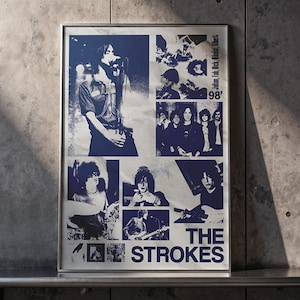 May include: A framed poster with a collage of blue and white images of The Strokes. The poster includes the band's name and the year '98'. The images show the band members performing on stage and in candid shots.