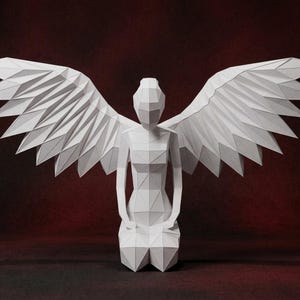 May include: A white, geometric paper sculpture of an angel kneeling with outstretched wings. The wings and body are composed of angular, folded paper sections. The background is a dark red gradient.