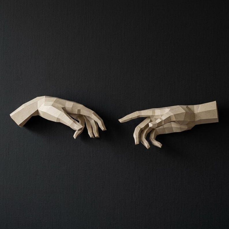 May include: Two beige papercraft hands, one reaching towards the other, against a dark background. The hands are constructed from geometric shapes, creating a low-poly effect. The artwork evokes the iconic 'Creation of Adam' scene.