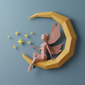 Peut inclure: Une fée en papier avec des ailes roses est assise sur un croissant de lune jaune, entourée d'étoiles jaunes. La fée est faite de papier rose et a un design géométrique. Le fond est de couleur bleu-gris uni.