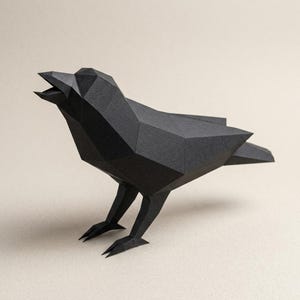 Puede incluir: Escultura geométrica de cuervo de papel negro con el pico abierto, de pie sobre dos patas. El cuerpo del ave está construido con múltiples planos planos y angulares, lo que le da una apariencia poligonal moderna. El cuervo está sobre un fondo neutro.