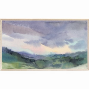 May include: Watercolor landscape painting featuring a mountain range under a cloudy sky. The artwork uses shades of green, blue, and purple, with a light wooden frame. The painting evokes a sense of tranquility and natural beauty.