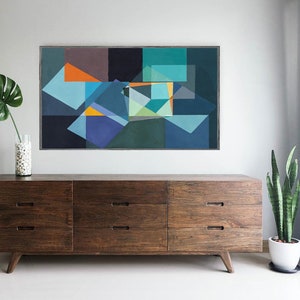 May include: Abstract geometric painting with blue, orange, and green shapes. The artwork hangs above a mid-century modern wooden dresser. A monstera leaf in a vase and a potted snake plant add to the decor.