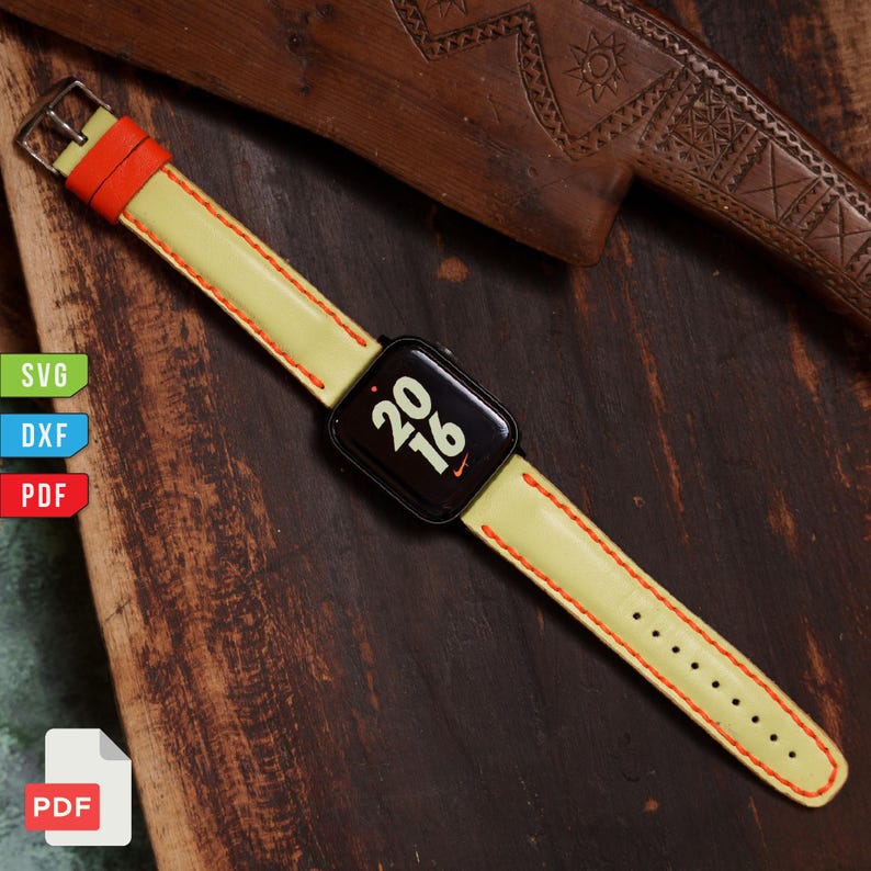 Pu&ograve; includere: Uno smartwatch nero con cinturino in pelle giallo chiaro e bordi arancioni. Il quadrante mostra i numeri "20 16". Il cinturino &egrave; cucito con filo arancione. L'orologio &egrave; su una superficie di legno scuro.