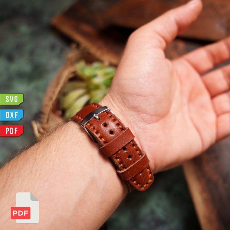 Pu&ograve; includere: Un cinturino per orologio in pelle marrone con fibbia argentata &egrave; allacciato a un polso. Il cinturino presenta cuciture visibili e fori multipli. L'immagine include anche il testo "SVG", "DXF", "PDF".