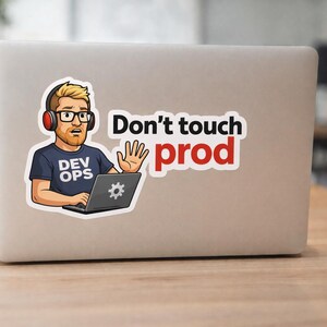 Könnte beinhalten: Ein Aufkleber auf einem Laptop zeigt einen Cartoon eines Mannes mit Kopfhörern und Brille mit dem Text "Don't touch prod". Der Mann hält seine Hand als Stoppgeste hoch und trägt ein T-Shirt mit "Dev Ops".