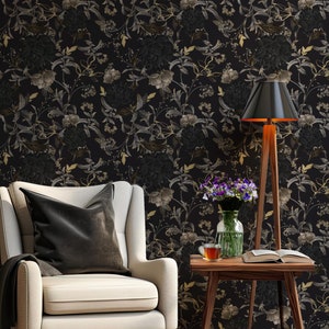 K&ouml;nnte beinhalten: Ein wei&szlig;er Sessel mit einem schwarzen Kissen steht vor einer schwarzen Tapeten mit Blumenmuster. Neben einem kleinen Holztisch mit einem Buch, einer Tasse und einer Vase mit lila Blumen steht eine schwarze Lampe mit einem Holzstativ.
