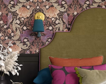 Puede incluir: Un dormitorio con papel pintado con motivos de pájaros y flores. La habitación incluye un cabecero verde, cojines coloridos y una mesita de noche turquesa con un jarrón y una taza de té. Una lámpara de pared turquesa está montada en la pared.