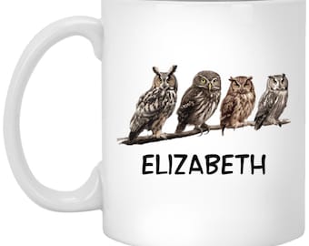 May include: White ceramic mug featuring a line of four brown and grey owls perched on a branch. The text "ELIZABETH" is printed below the owls.