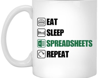 May include: White ceramic mug with a black and green design. The mug features a list of activities: Eat, Sleep, Spreadsheets, Repeat. The icon for Spreadsheets is a green Excel spreadsheet icon.