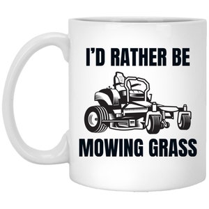 May include: White ceramic mug with a black graphic of a riding lawnmower and the text "I'd rather be mowing grass".