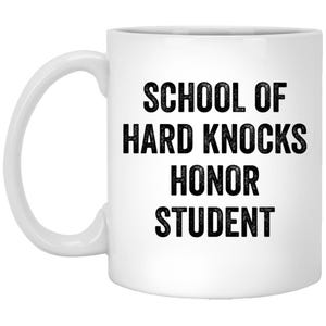 Könnte beinhalten: Weiße Keramik-Kaffeetasse mit schwarzem Text, der "School of Hard Knocks Honor Student" lautet.