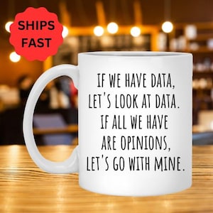 Pode incluir: Caneca de café de cerâmica branca com texto preto que diz: "Se temos dados, vamos olhar para os dados. Se tudo o que temos são opiniões, vamos com a minha."