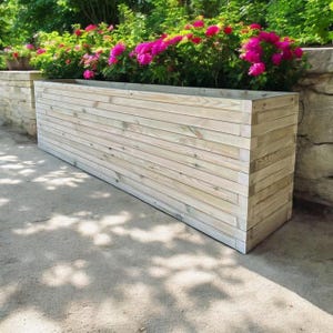 May include: A long, rectangular wooden planter box with a natural finish. The planter is made of horizontal wooden planks and is sitting on a concrete surface.