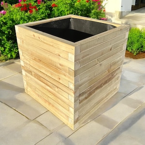 May include: A square wooden planter box with a black liner. The planter is made of natural wood and has a rustic look.