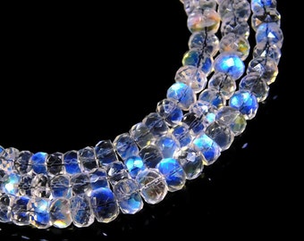 Puede incluir: Una hebra de cuentas de piedras preciosas blancas iridiscentes con forma de lágrima facetada. Las cuentas están enhebradas en un hilo negro y tienen un brillo iridiscente azul.