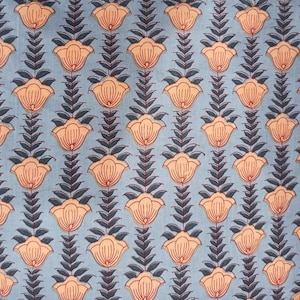 May include: A repeating pattern of stylized flowers and leaves on a light blue background. The flowers are peach-colored with red outlines, and the leaves are dark gray. The design is symmetrical and creates a floral textile pattern.