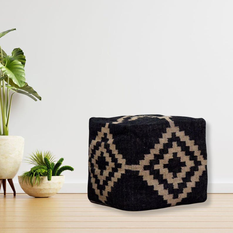 May include: Black and beige patterned square ottoman with a geometric design.