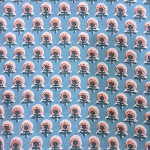 Peut inclure: Un tissu bleu clair avec un motif floral r&eacute;p&eacute;titif. Chaque fleur a un centre p&ecirc;che, des p&eacute;tales blancs et des tiges et feuilles vertes. Le motif est uniform&eacute;ment r&eacute;parti sur le tissu.