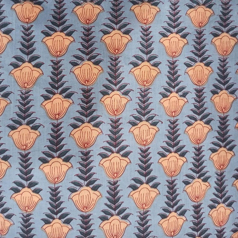 May include: A repeating pattern of stylized flowers and leaves on a light blue background. The flowers are peach-colored with red outlines, and the leaves are dark blue. The design is symmetrical and creates a floral textile pattern.