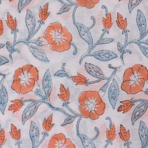 May include: White fabric with a repeating floral pattern. The design features orange flowers, light blue leaves, and orange buds on stems. The pattern is evenly spaced across the fabric.