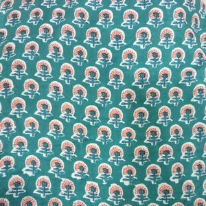 Peut inclure: Un tissu de couleur sarcelle avec un motif floral r&eacute;p&eacute;titif. Les fleurs sont de couleur p&ecirc;che avec des accents blancs et sarcelle. Le motif est uniform&eacute;ment espac&eacute;, cr&eacute;ant un design visuellement attrayant.