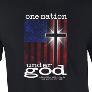 May include: Black t-shirt with a distressed American flag design and a cross. The text "one nation under god indivisible, with liberty and justice for all." is printed below the flag.