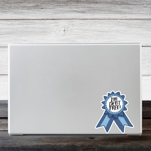 a laptop computer with a blue ribbon sticker on it