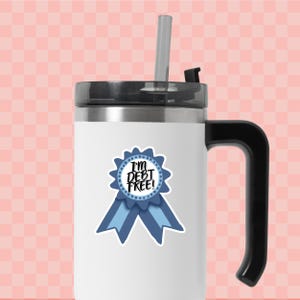 a white and black coffee mug with a blue ribbon around it